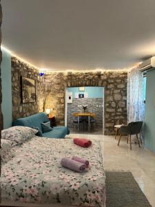 a bedroom with two beds and a stone wall at Apartments Hana in Makarska