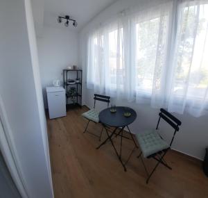 a dining room with a table and chairs and windows at Rooms Depikolo in Krk