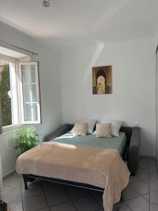 a bed in a bedroom with a picture on the wall at Cozy studio sur la promenade in Nice