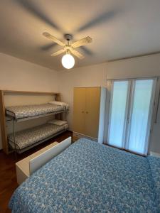 a bedroom with two bunk beds and a ceiling fan at FOSCOLO Sunset House in Lido di Jesolo
