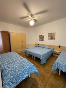 a room with two beds and a ceiling fan at FOSCOLO Sunset House in Lido di Jesolo +53 photos
