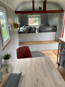 a dining table in a tiny house with two beds at Bauwagen Villa Sweden in Rauenberg +28 photos