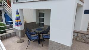 a patio with a table and chairs and an umbrella at Apartments Mandić - More in Kraj +8 photos