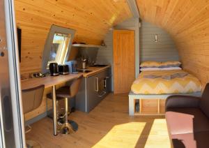 a small room with a bed and a desk in a cabin at Ben View Pod in Fort William