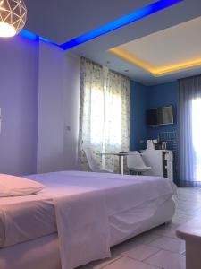 una camera da letto con un grande letto bianco e un tavolo di Xenios Zeus a Iraklitsa