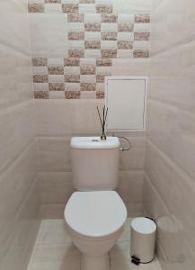 a bathroom with a white toilet with a picture on the wall at Heart of Kaunas Apartament in Kaunas