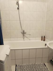 a white bathroom with a tub and a sink at Heart of Kaunas Apartament in Kaunas