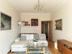 a living room with a white couch and a table at Heart of Kaunas Apartament in Kaunas