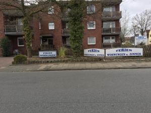 ein Gebäude mit Schildern an der Straßenseite in der Unterkunft Haus Elbe -Wohnung 14- Zentral in Döse in Cuxhaven