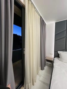 a bedroom with a bed and a large window at Center Park Apartment in Sandanski