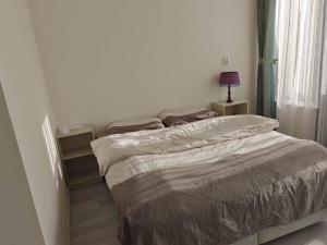 two beds in a bedroom with a lamp on a table at Bredalucia in Breda