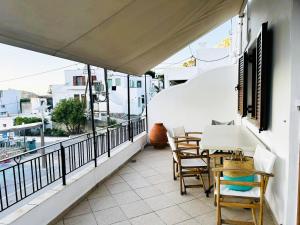 a balcony with a table and chairs on a building at Calliope's house in Skiros