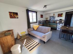 a living room with a couch and a kitchen at Meublé cosy tt confort, arrivée autonome, proche Cholet et puy du f in Trémentines