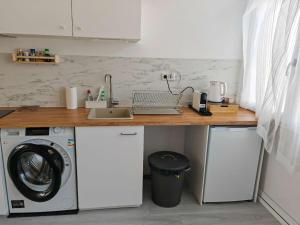 a kitchen with a sink and a washing machine at Bredalucia in Breda