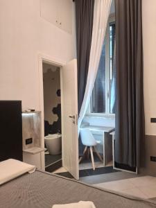 a bedroom with a bed and a bathroom with a window at Hotel Viennese in Rome
