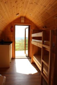 a room with a bunk bed and a doorway at Bowdens Crest Glamping Pods -Adults Only in Aller
