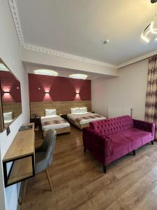 ein Wohnzimmer mit zwei Betten und einem lila Sofa in der Unterkunft Van Orient Hotel in Van + 14 Fotos