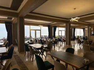 ein Restaurant mit Tischen, Stühlen und Fenstern in der Unterkunft Van Orient Hotel in Van