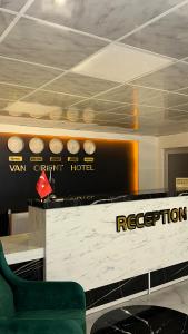 ein Raum mit Rezeption und einem grünen Stuhl in der Unterkunft Van Orient Hotel in Van