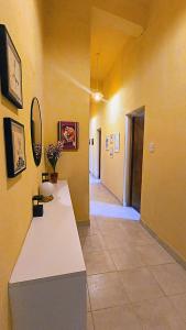 a hallway with yellow walls and a counter in a room at Jujuy Hub Hostel in Reyes