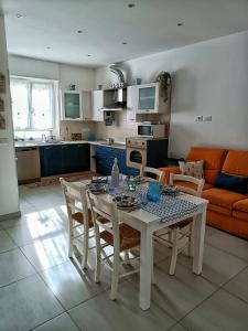a kitchen and living room with a table and chairs at Appartamento Mimosa in Boissano +14 photos