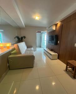 a living room with a couch and a flat screen tv at Cobertura 435 - In mare bali in Parnamirim