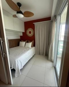 a bedroom with a white bed with a red wall at Cobertura 435 - In mare bali in Parnamirim