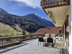 a balcony with a table and chairs and mountains at Ferienhaus Bergblick in Sellrain