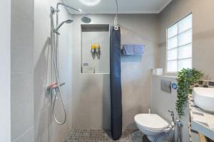 a bathroom with a shower with a toilet and a sink at Appartement calme avec cachet (20 min de Paris) in Maisons-Laffitte