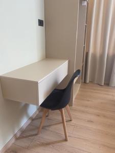 a black chair sitting under a white desk at Real City Nikis in Athens
