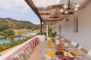 un tavolo con cibo e vista sulla piscina di Quinta do Silencio a Tavira