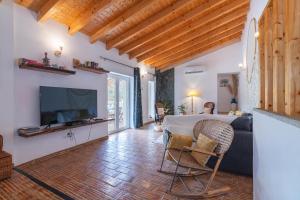 un soggiorno con tavolo, divano e TV di Quinta do Silencio a Tavira