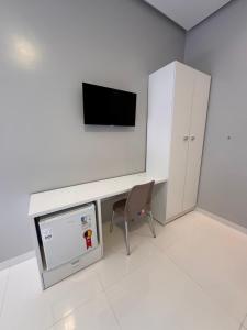 a room with a desk with a tv and a chair at Casa Alter do Sol - 3 suites in Alter do Chao