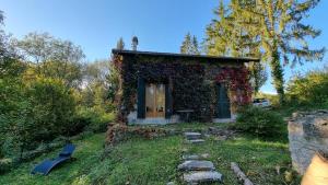 a small house covered in ivy on a hill at Designer House with Breathtaking View in Orry-la-Ville