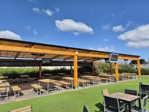 ein Picknickplatz mit Tischen und Stühlen auf einem Feld in der Unterkunft Bella-Mays Holiday Hideaway in Lincolnshire
