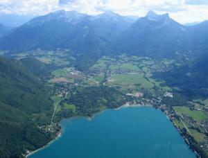 eine Luftansicht auf eine Stadt und einen See in der Unterkunft Entre lac et montagne in Doussard