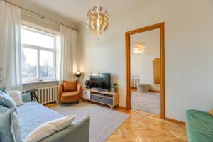 ヴィリニュスにあるTyzen39&38 Luxury Apartmentのリビングルーム(ベッド1台、鏡付)