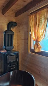 a stove and a table in a room with a window at Brvnara Topilo in Niš