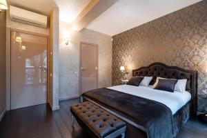 een slaapkamer met een groot bed en een bank. bij BIRUTE LUXURY 2 BEDROOMS in Palanga