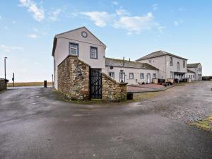 a large white house with a stone wall at North Lodge Retreat Allonby in Maryport