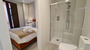 ein Bad mit Dusche und ein Bett mit Handtüchern in der Unterkunft Suspiro 201 Elegant Suite in Granada + 27 Fotos
