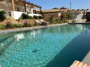 una piscina con acqua blu davanti a una casa di Quinta do Silencio a Tavira