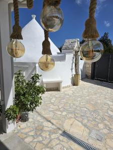 a patio with three lights hanging from a house at Il Trullo L'amore di Nonna in Martina Franca