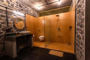 a bathroom with a shower and a sink and a toilet at Dang Forest Retreat in Bāori