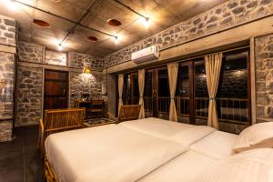 a bedroom with a large bed and some windows at Dang Forest Retreat in Bāori