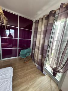 a room with a window with a green chair next to it at Chambre Lavighiu in Patrimonio