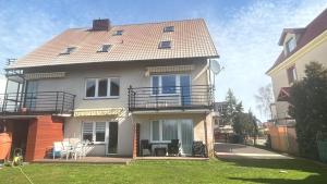 a large house with a balcony and a yard at Kwatery u Szymka in Jastarnia