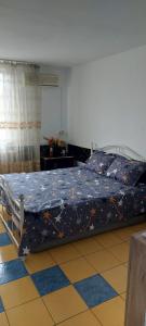 a bedroom with a bed with a blue comforter at Olimp SeaSun in Olimp +3 photos