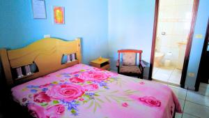 a bedroom with a pink bed with roses on it at Meu Cantinho in São Pedro