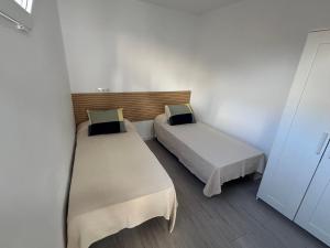 a small room with two beds in it at Conil Playa 200 metros Casa barrio de los pescadores in Conil de la Frontera